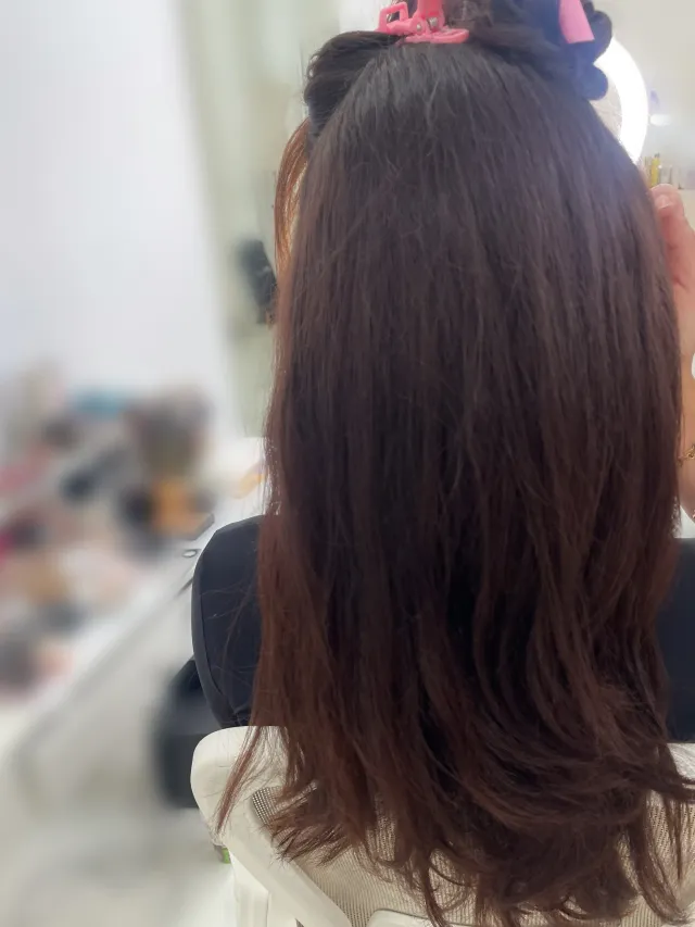 Rückenansicht von dunkelbraunem Haar mit sanften Wellen, natürlicher Look für Brautstyling in Hamburg